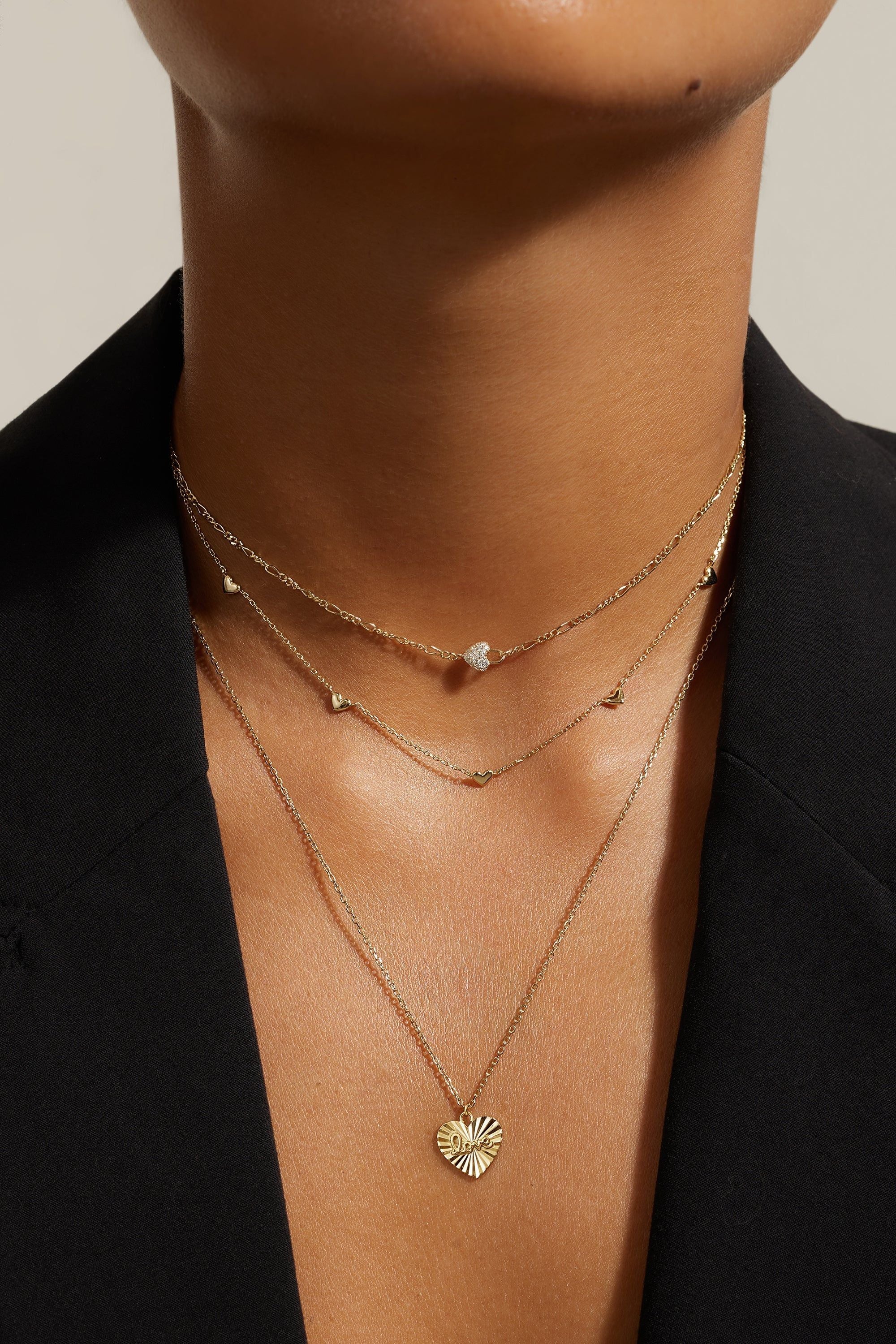 Layered gold necklaces featuring the Multi Micro Heart Necklace in 14k gold plated design