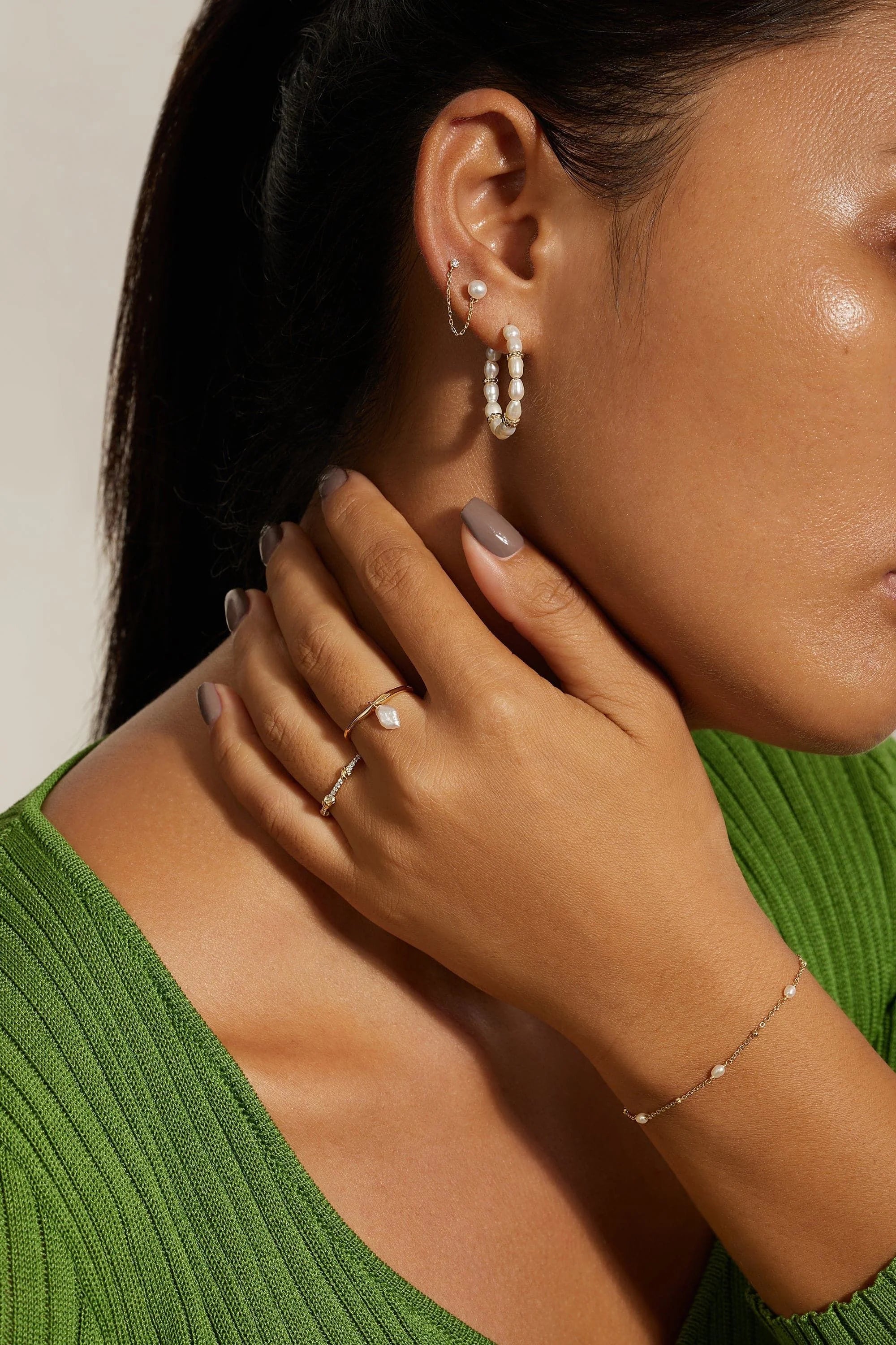 Woman wearing pearl jewelry with 14k gold plating and sterling silver Pearl Beaded Huggie Hoops