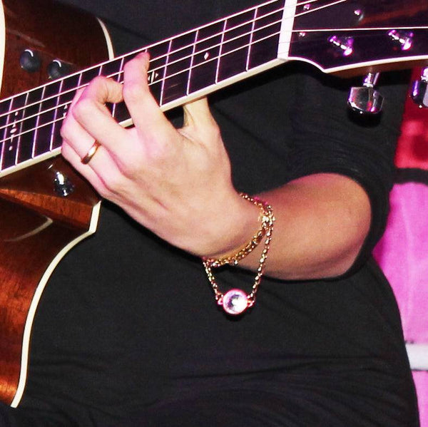 Person playing guitar while performing Highly Sensitive album in the US wearing EKLEXIC.