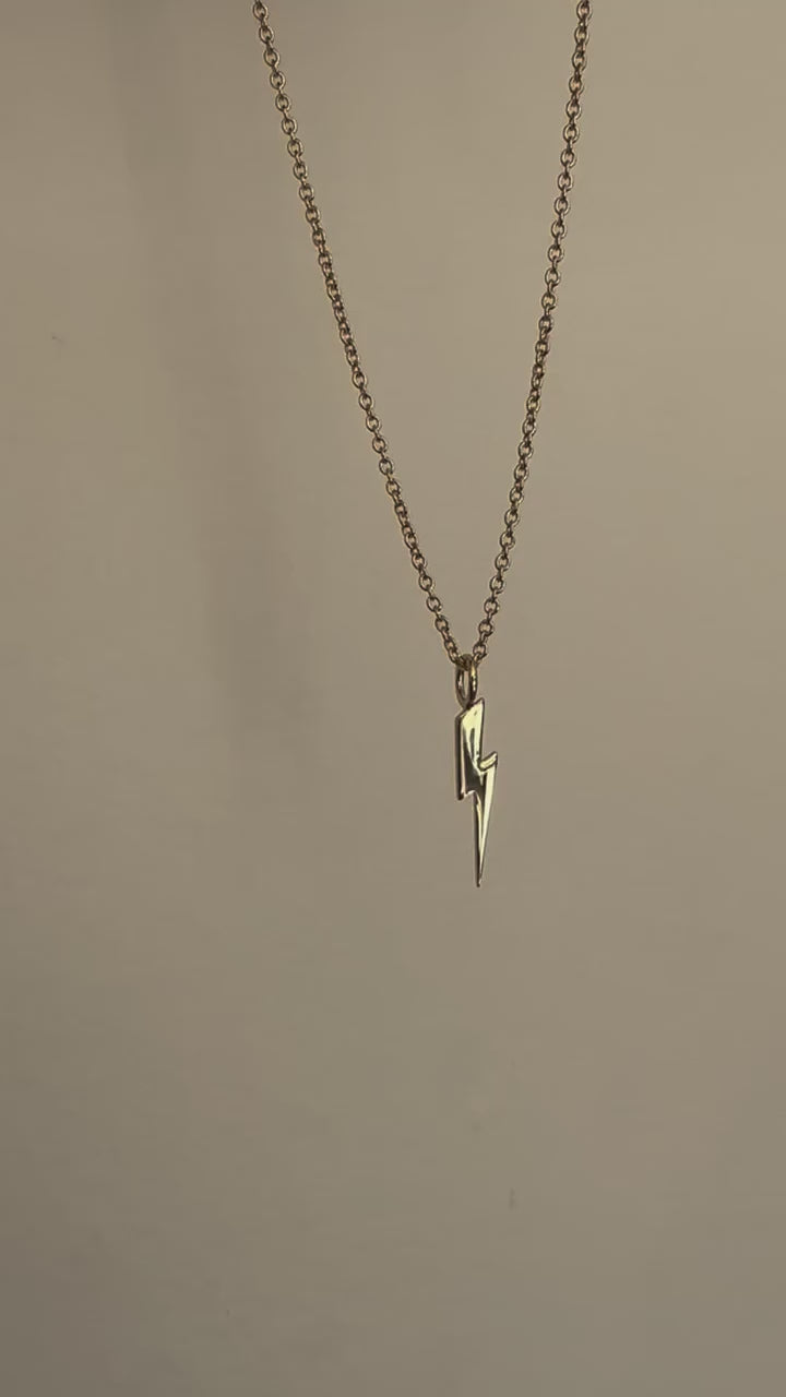 a necklace with a lightning bolt hanging from it