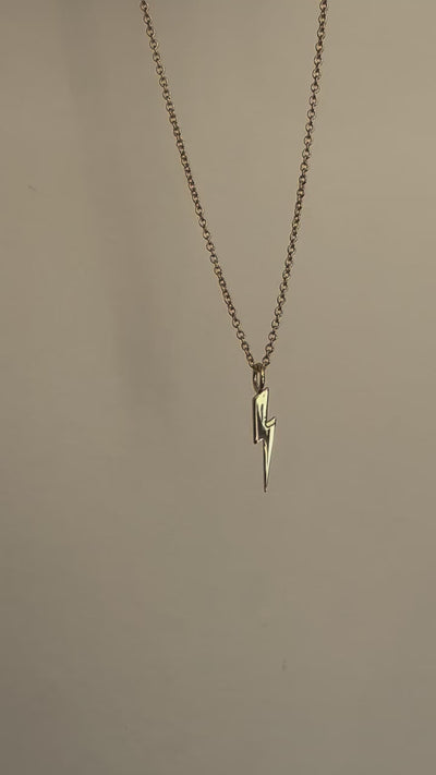 a necklace with a lightning bolt hanging from it