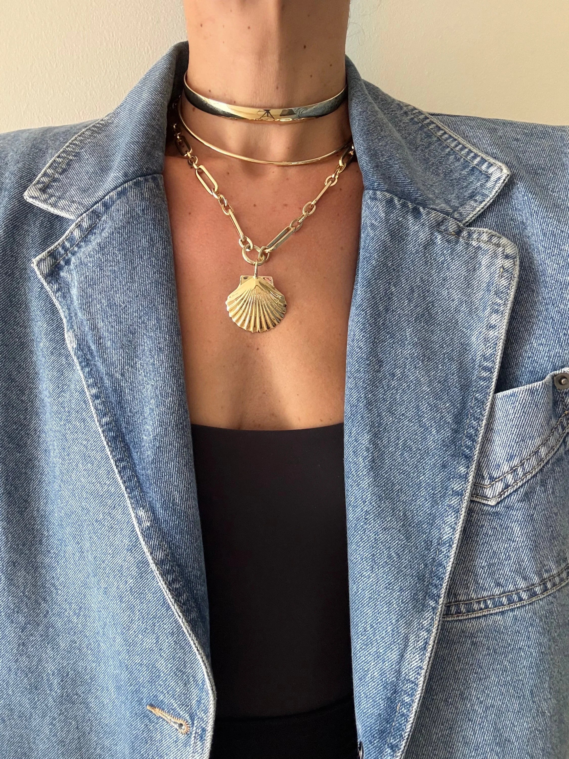 Person wearing denim jacket black top layered gold necklaces with shell pendant Shelly Pendant