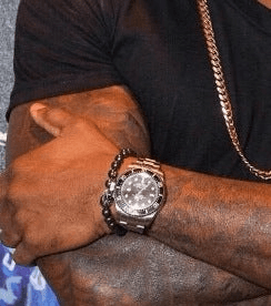 Silver wristwatch with black bezel paired with Tyson Beckford’s Hematite Bead Bracelet.