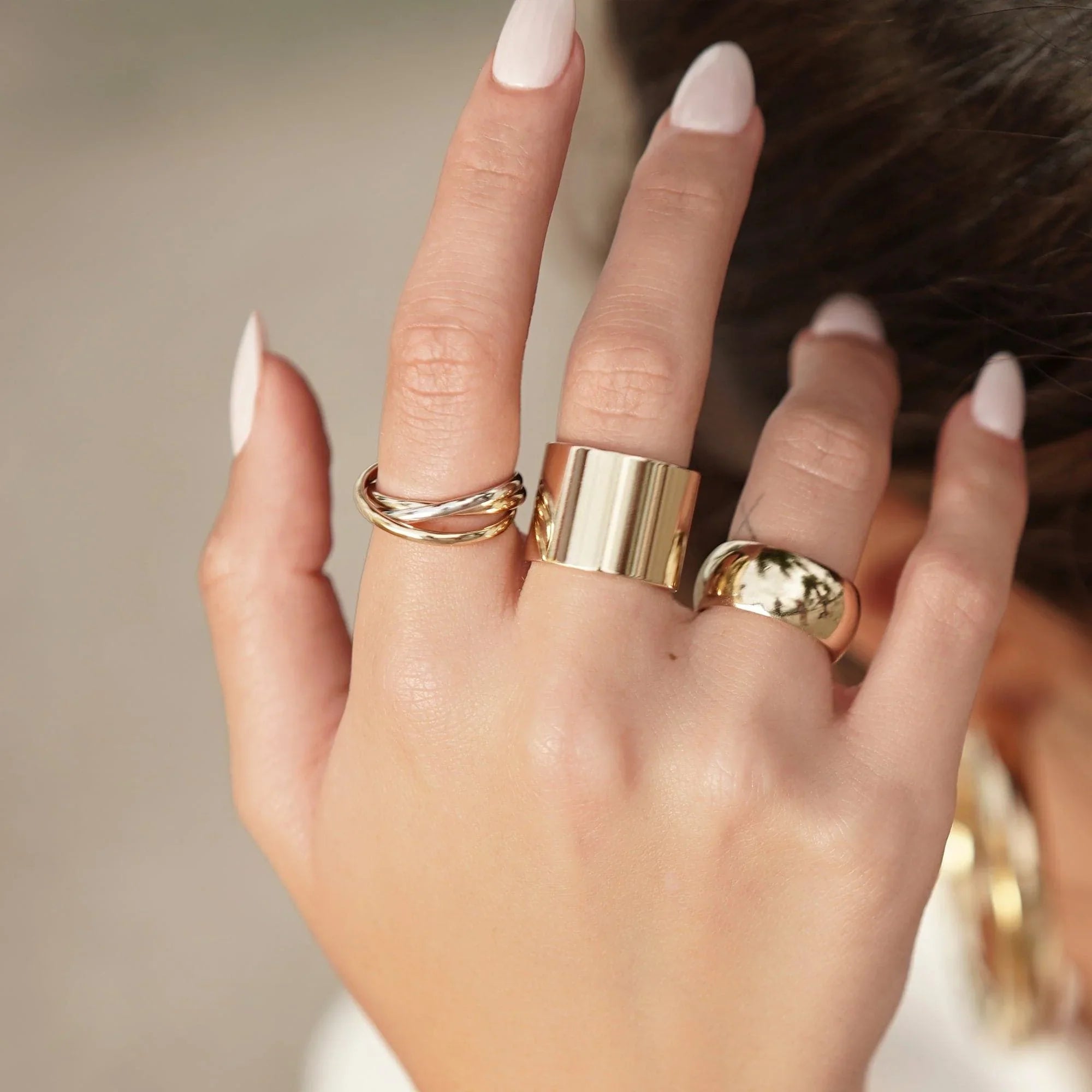 Hand with gold rings showcasing the stylish Thick Flat Ring product