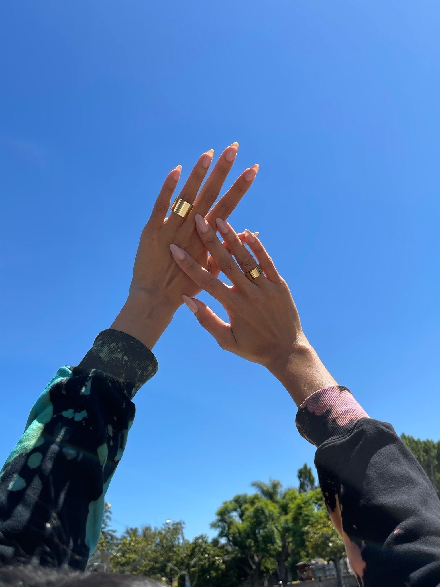 Two hands showcasing a Thick Flat Ring with recycled brass plating and clear protective coating