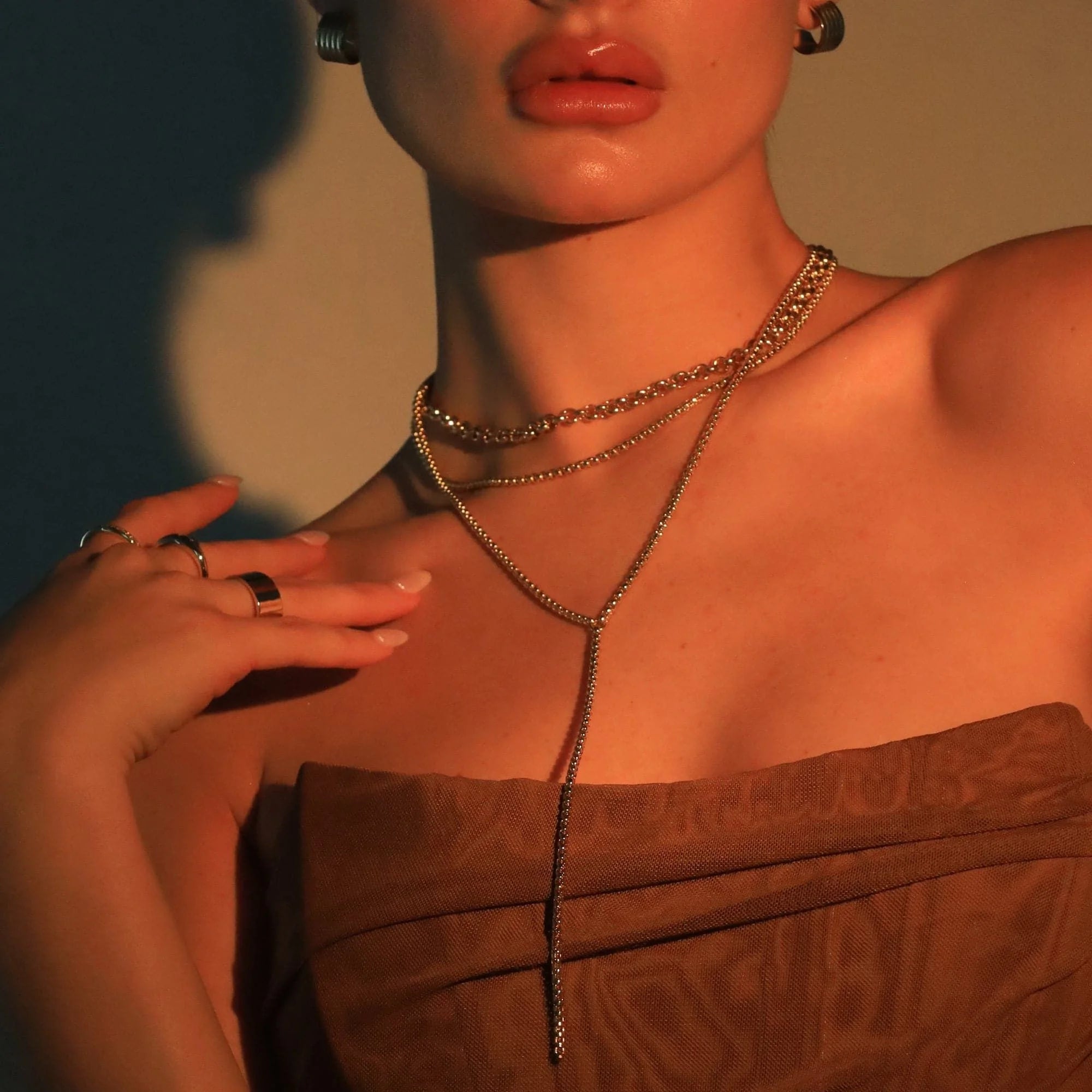 Woman wearing layered gold luciana box chain lariat necklace with venetian box chain style