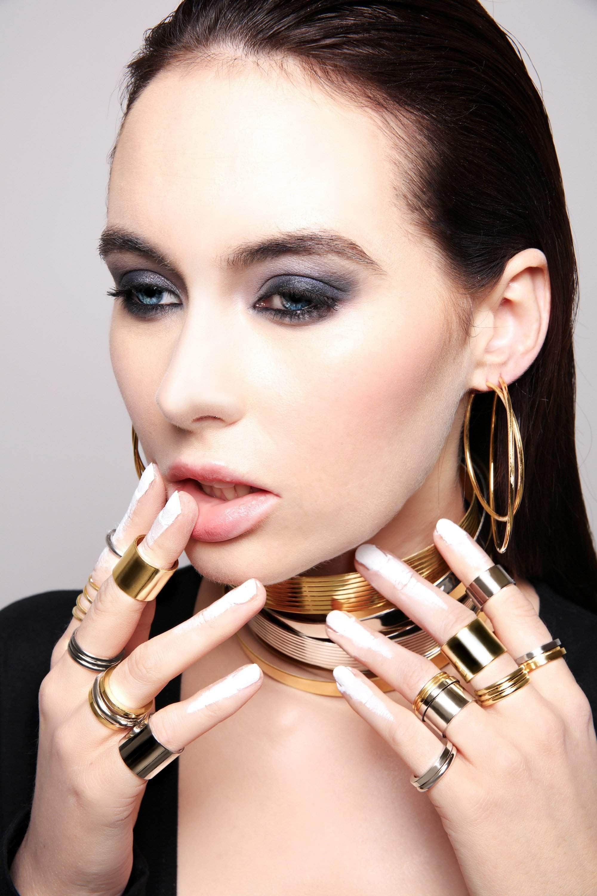 Woman wearing a brass triple domed ring with elegant gold jewelry accents