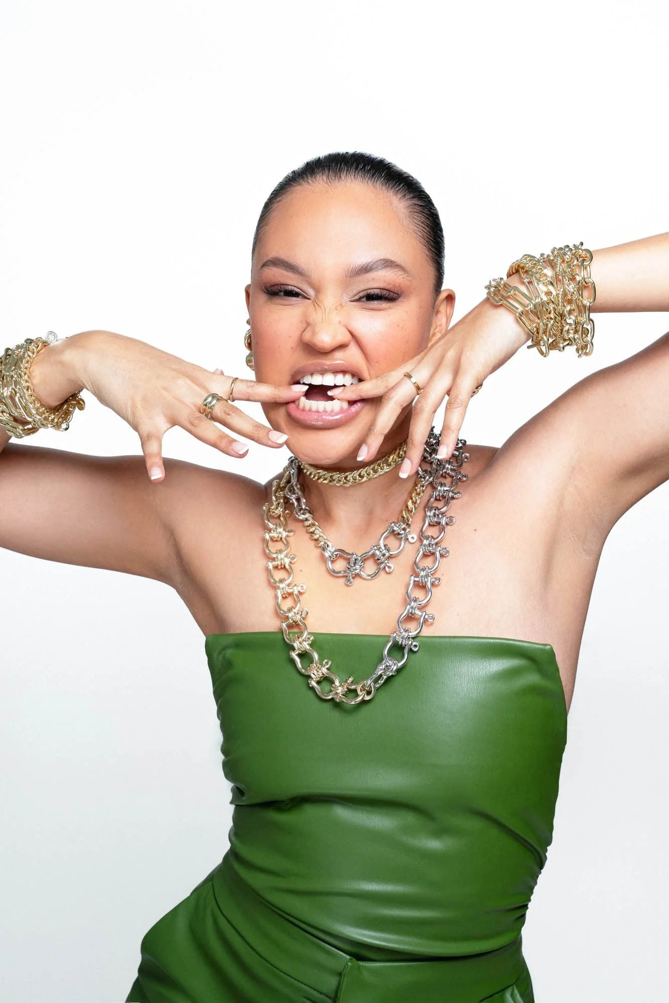 Woman wearing green strapless top with gold jewelry showcasing the Two Toned Hendrick Necklace in recycled brass plating