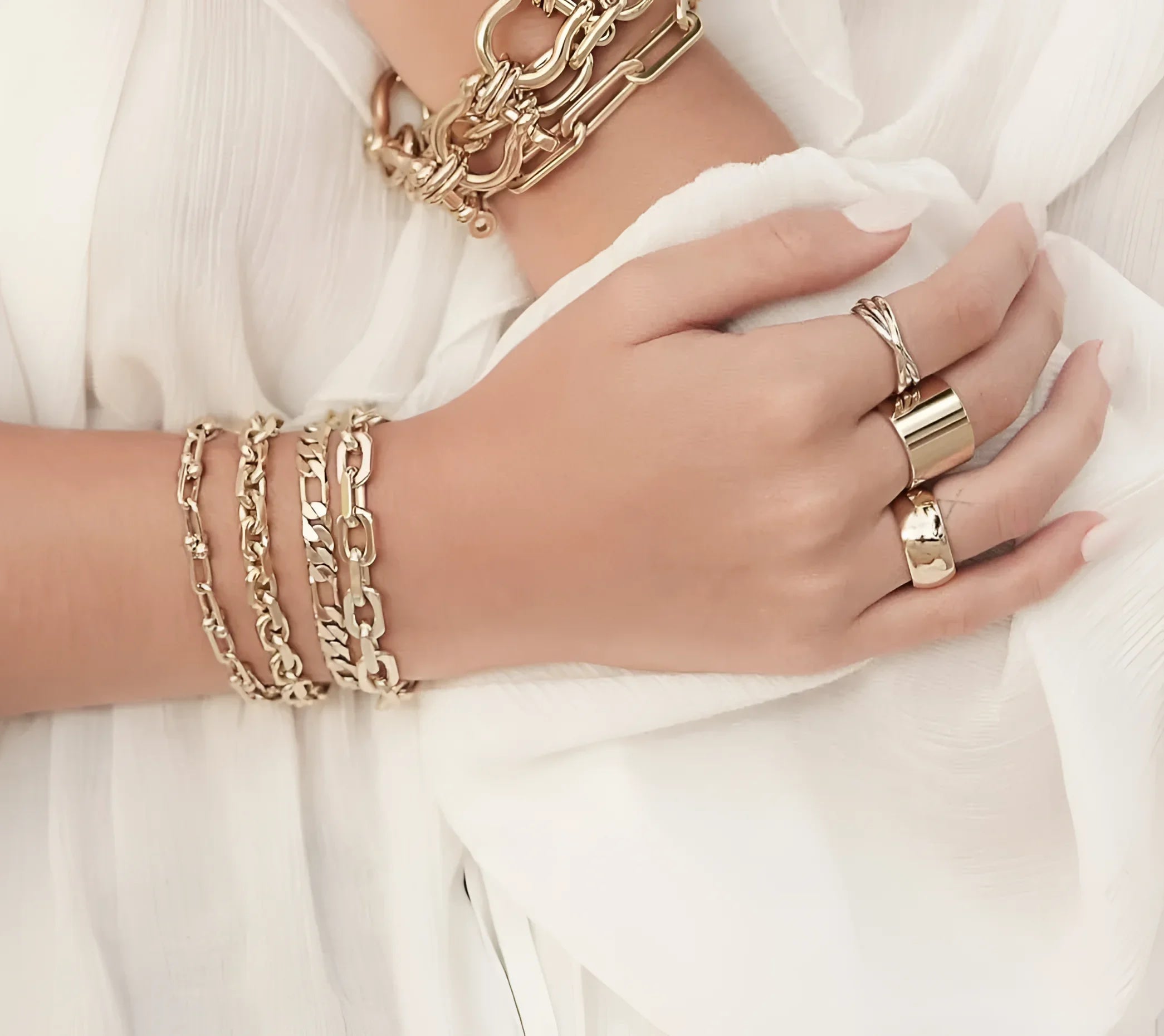 Gold-toned jewelry on a hand featuring a Two Toned Triple Domed Roll Ring