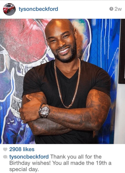 Tyson Beckford smiling while wearing a stylish Hematite Bead Bracelet.
